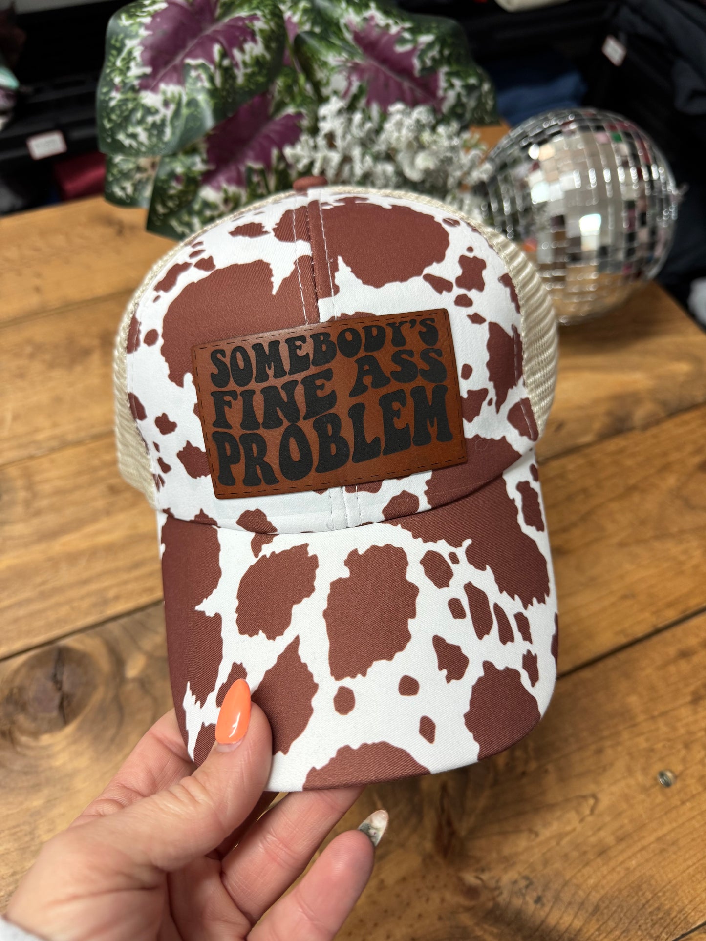 Somebody’s fine ass problem brown cow print crisscross ponytail hat